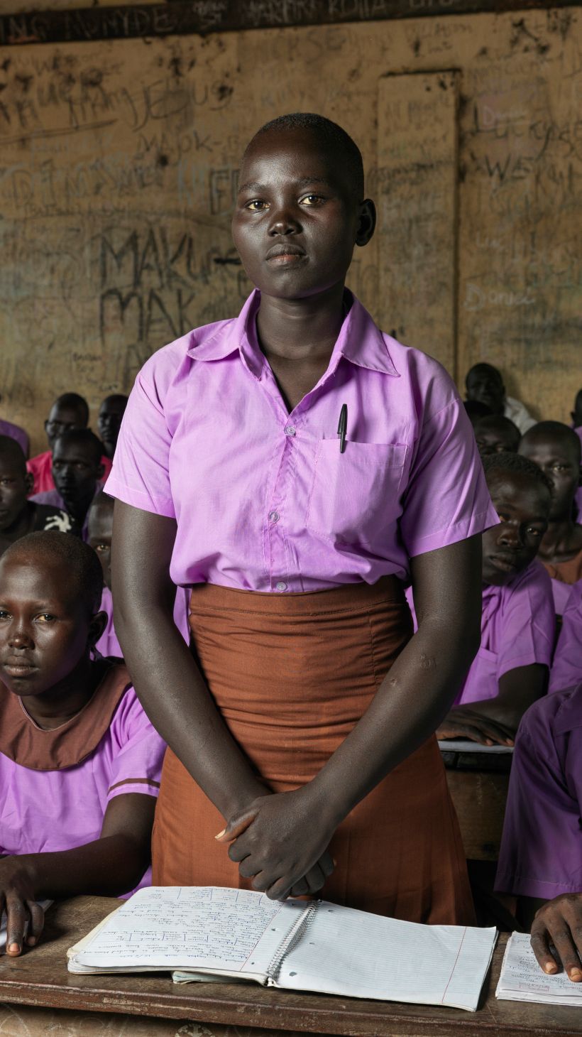 A photo of Hellena standing in a classroom of students sitting.
