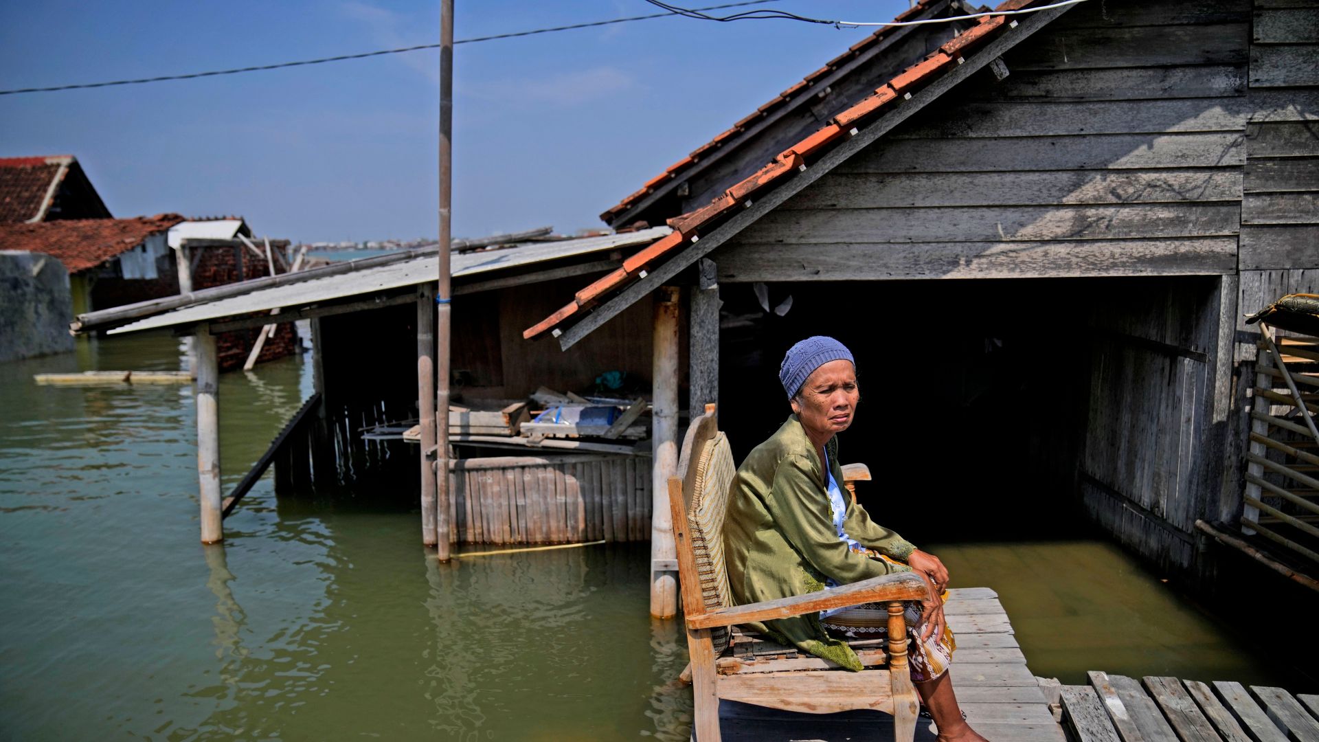 Mar'iah sits outside her house while waiting for the flood water to subside