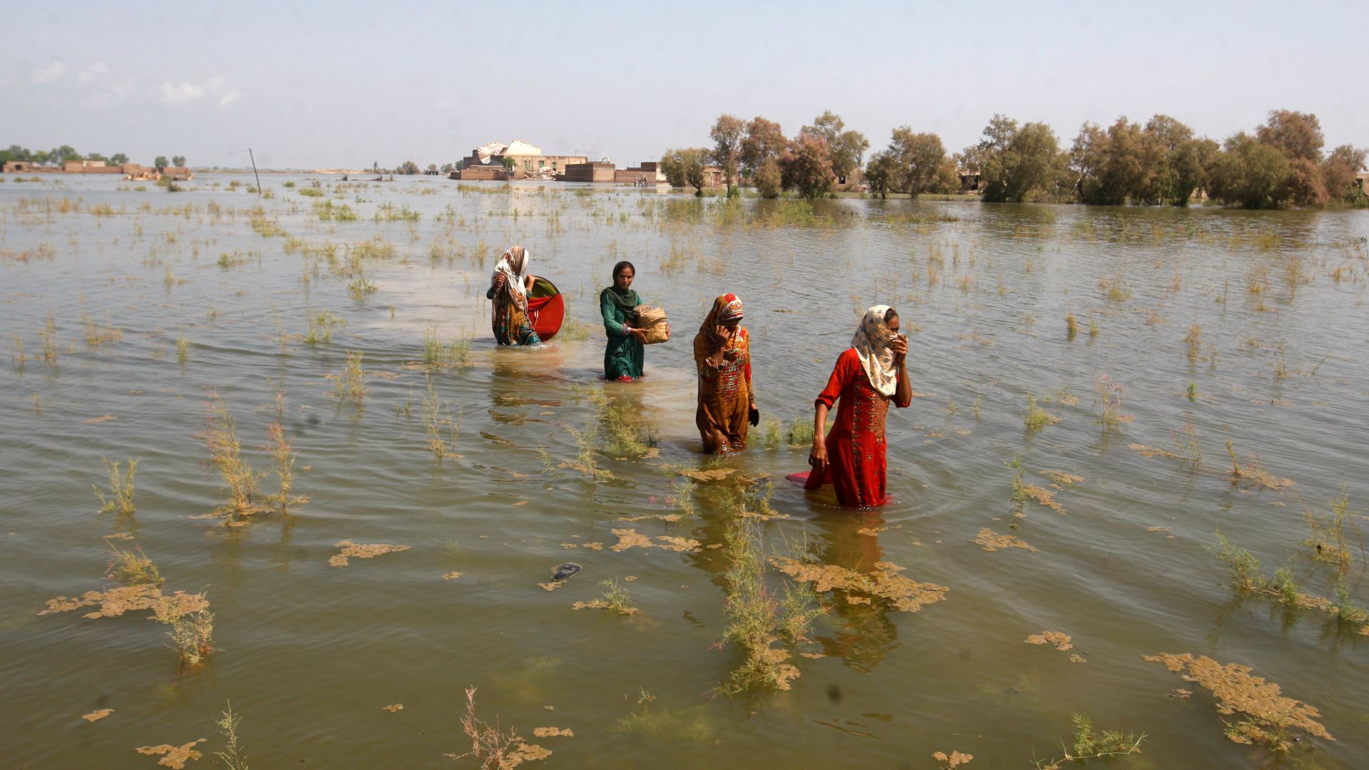 Pakistani women wade through floodwaters
