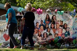 Visitors walk past a make-shift memorial at Robb Elementary School, in Uvalde, Texas