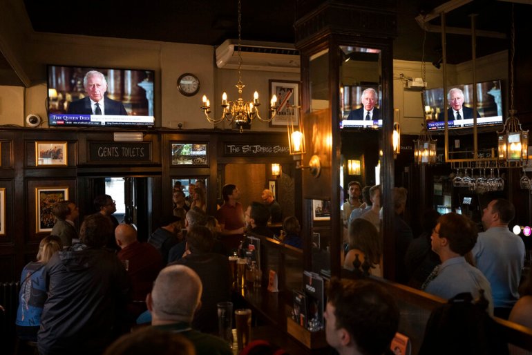 People watch a broadcast of Britain's King Charles III first address to the nation as the new King following the death of Queen Elizabeth II, 
