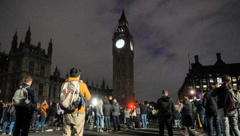 People standing on Westminster Bridge turned towards an illuminated Big Ben during a minute of silence for the queen