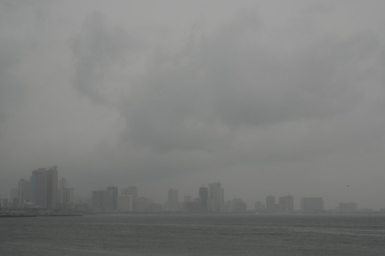Manila's skyline obscured by storm clouds and torrential rain