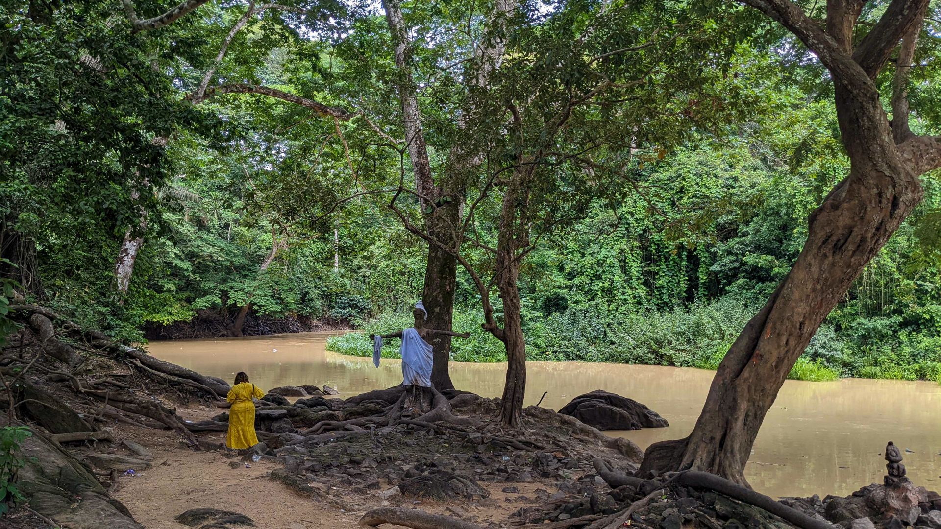A female worshipper of Osun goes to the polluted section of the river within the sacred grove in Osogbo the state capital to pray to the goddess. [Eromo Egbejule/Al Jazeera]