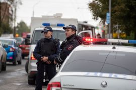 Russian policemen stand near the scene of a school shooting.