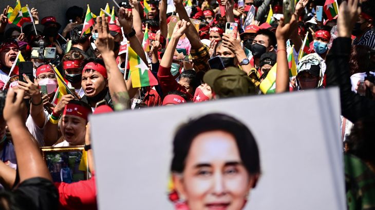Protesters show the three-finger salute and hold photos of jailed Myanmar leader Aung San Suu Kyi during a demonstration against Myanmar military government in July 2022