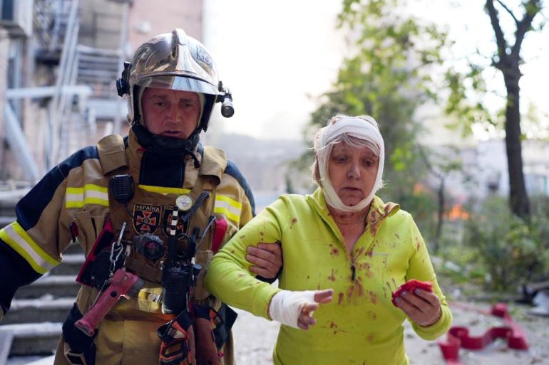 Ukrainian State Emergency Service shows a rescuer helping an injured woman at the site of shelling in Kyiv.