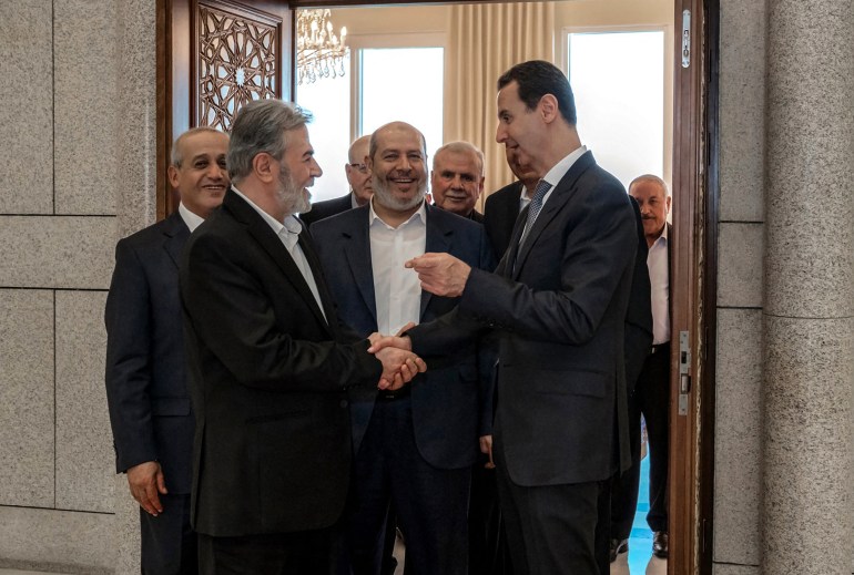 This handout picture released by the Syrian Presidency, shows Syia's President Bashar al-Assad (R) receiving Hamas chief of Arab relations, Khalil al-Hayya (C) and the leader of Palestinian militant group Islamic Jihad, Ziad al-Nakhala (L) in the capital Damascus, on October 19, 2022.
