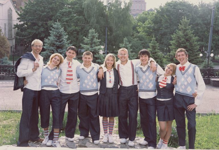 A photo of a group of people standing side by side wearing uniforms.