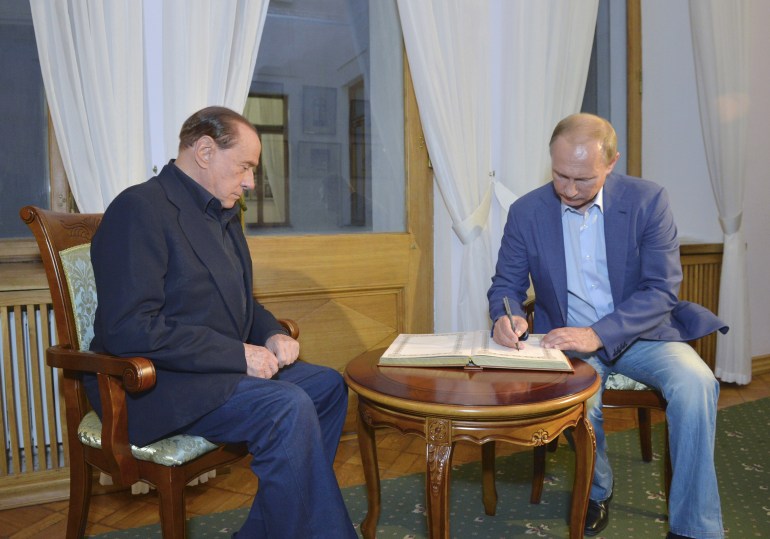 Russian President Vladimir Putin (R) and former Italian prime minister Silvio Berlusconi sign a guest book as they visit Livadia Palace outside the town of Yalta, Crimea