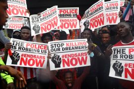 Demonstrators carry banners during a protest over police brutality