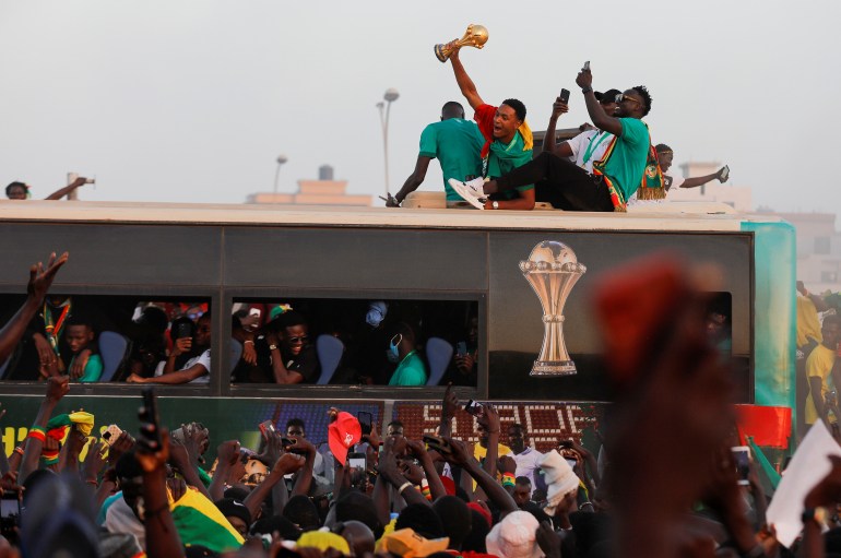 Members of the Senegal National Soccer Team celebrate as they arrive in a bus after their Africa Cup win, in Dakar, Senega