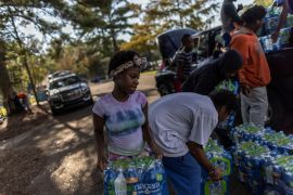 Volunteers carry water bottles in Mississippi amid a water crisis.