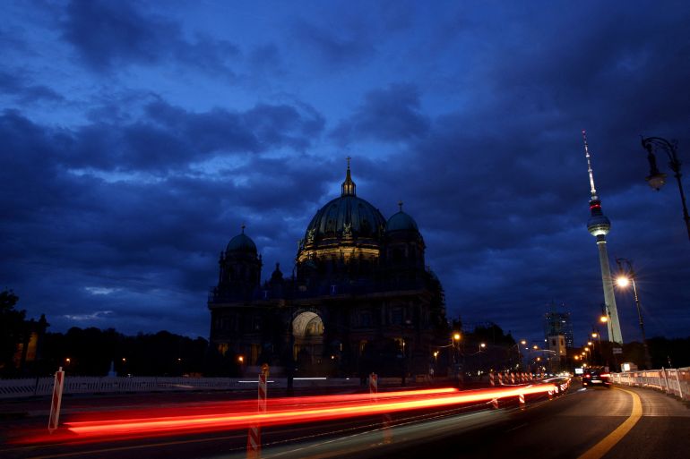 The Television Tower glows at dusk next to the Protestant Berlin Cathedral with a reduced lighting to save energy due to Russia's invasion of Ukraine