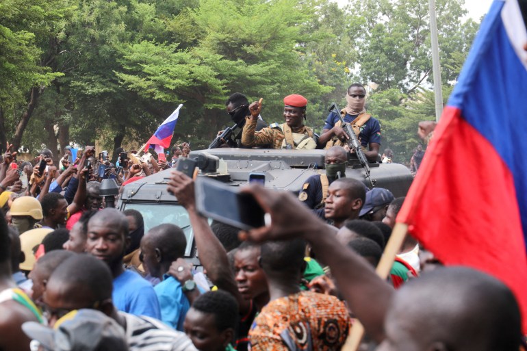 Burkina Faso's self-declared new leader Ibrahim Traore is welcomed by supporters holding Russian's flags as he arrives at the national television standing in an armoured vehicle in Ouagadougou, Burkina Faso October 2, 2022.