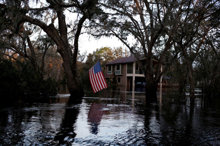 A U.S. flag is seen in a flooded rural area after Hurricane Ian caused widespread destruction in Arcadia, Florida, U.S., October 4, 2022.