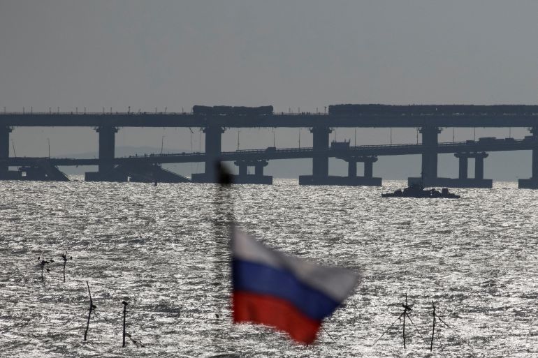 The Kerch bridge with a russian flag on a mast in the foreground.