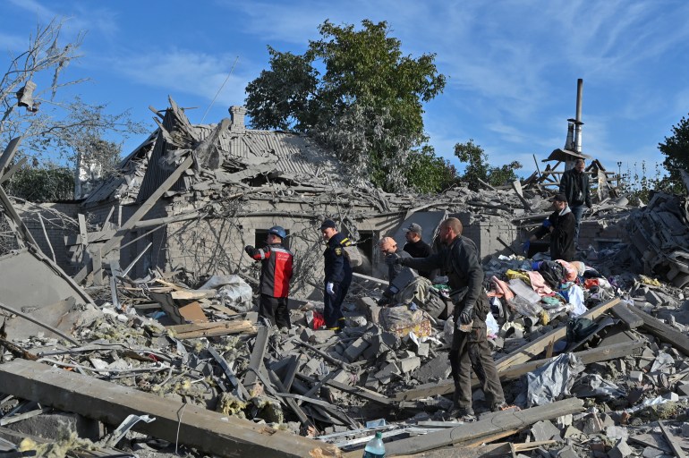 Rescuers and residents remove debris at an apartment block reduced to rubble by Russian shelling in Zaporizhzhia, Ukraine..