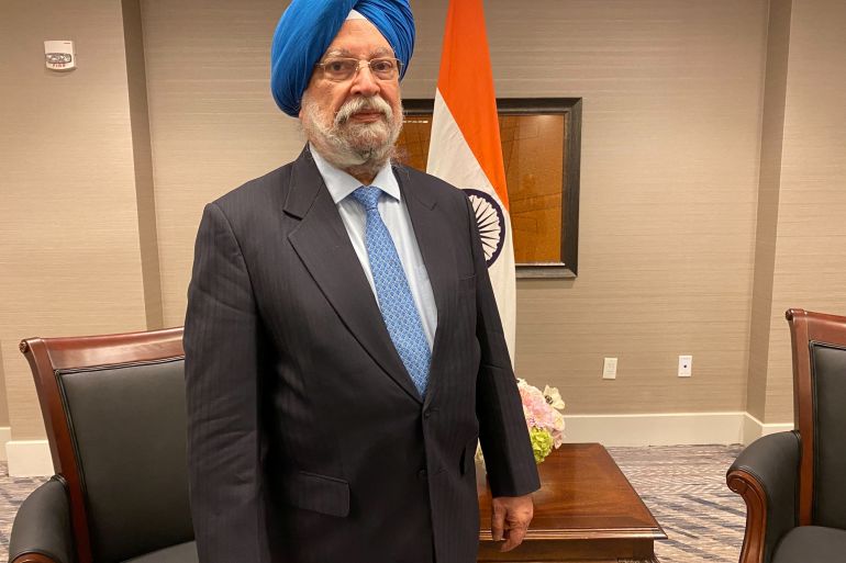 Hardeep Singh Puri in office, with flag, table and desk behind him
