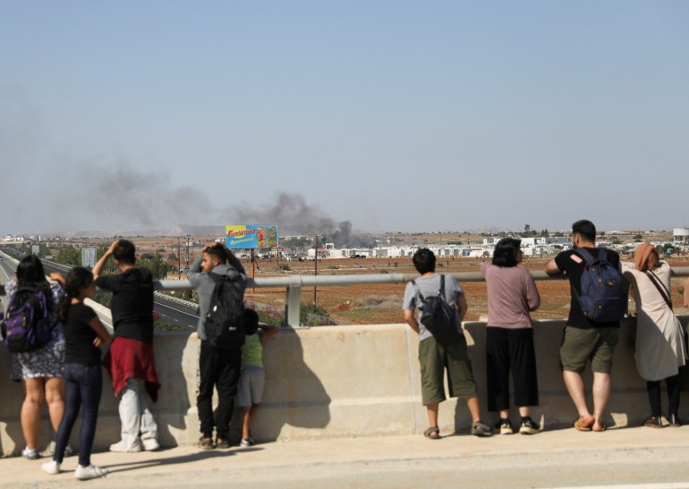 Migrants watch a fire outside Pournara refugee camp during clashes in Kokkinotrimithia on the outskirts of Nicosia