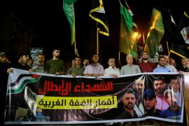Palestinians hold a banner of six killed