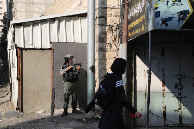 Israeli forces stand guard during an army raid in the Shuafat Refugee Camp