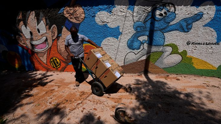 An electoral worker pushes a dolly of electronic voting machines, delivered to a polling station at a school in preparation for the upcoming general election, in Brasilia, Brazil, Friday, Sept. 30, 2022. Brazilians head to polls on Oct. 2 to elect a president, vice president, governors and senators. (AP Photo/Eraldo Peres)