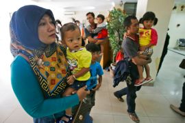 Indonesian parents bring their children to a hospital in 2016 [File: Achmad Ibrahim/AP]