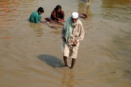 An elderly man wade through floodwaters in Charsadda, Pakistan, Thursday, Sept. 1, 2022. Pakistani health officials on Thursday reported an outbreak of waterborne diseases in areas hit by recent record-breaking flooding, as authorities stepped up efforts to ensure the provision of clean drinking water to hundreds of thousands of people who lost their homes in the disaster.