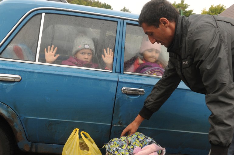 A child is seen looking through a car window as they flee the war in Ukraine
