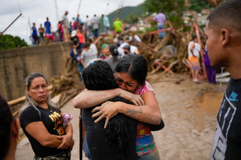 Distraught residents hug each other amid the devastation of the landslide in Venezuela.