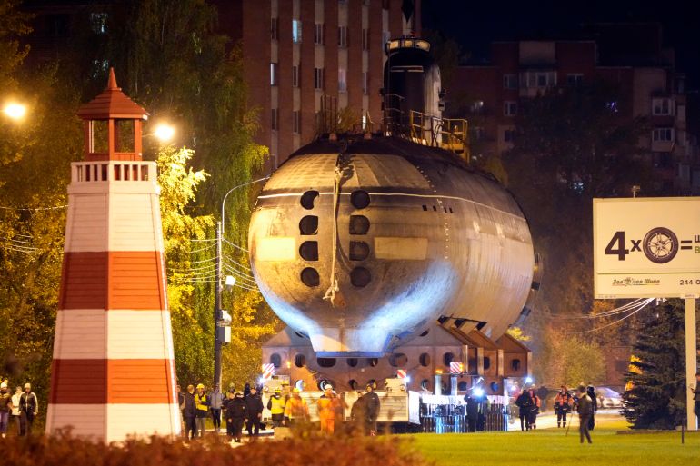 The bow of the Soviet submarine K-3 'Leninsky Komsomol' is transported by a platform along the street from the pier to the museum where it will be assembled with the stern and installed as a museum, in the city of Kronstadt, outside St. Petersburg, Russia, Wednesday, Oct. 12, 2022. K-3 'Leninsky Komsomol' (NATO reporting project name "November"), the first nuclear submarine of the Soviet Union was built in 1957 and based in Soviet Navy's Northern Fleet in Murmansk region. In 1967, while transiting the Norwegian Sea, 39 crew members of K-3 died in bow compartments in the fire. (AP Photo/Dmitri Lovetsky)