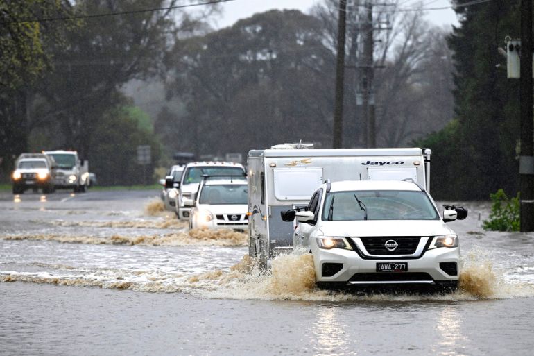 Cars slosh through a flooded road in Heathcote in Australia's Victoria State on October 13, 2022 [James Ross/AAP via AP]