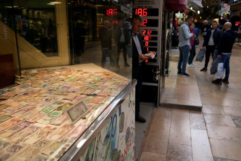 A man holds bank notes as he leaves a currency exchange shop in Istanbul, Turkey