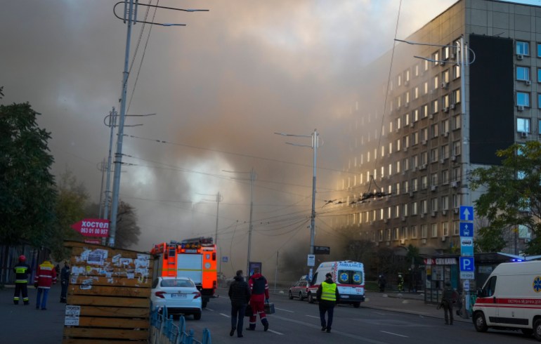 Smoke rises from a street in Kyiv as rescuers reach the scene.