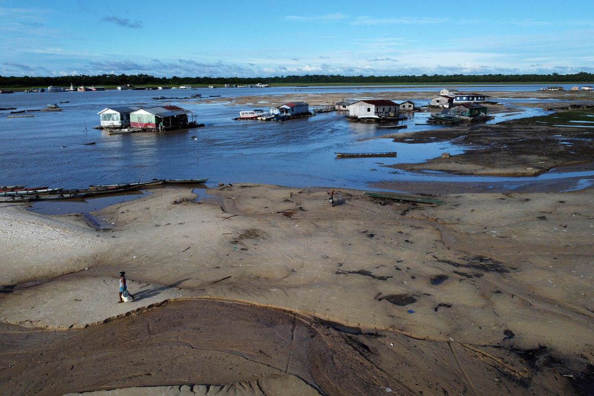 A woman walks in an area impacted by drought near the Solimões River, in Tefe, Amazonas state, Brazi