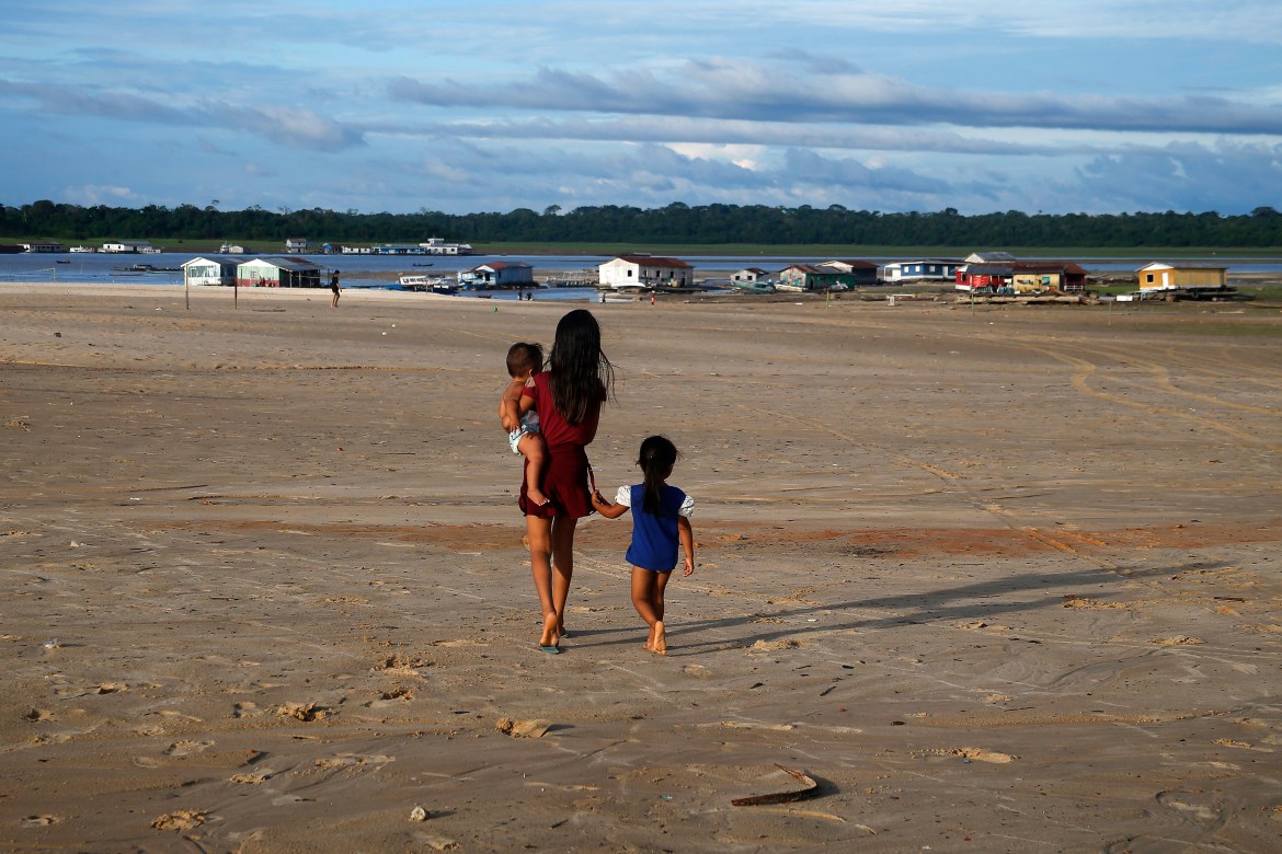 Children walk in an area impacted by the drought near the Solimões River, in Tefe, Amazonas state, Brazil