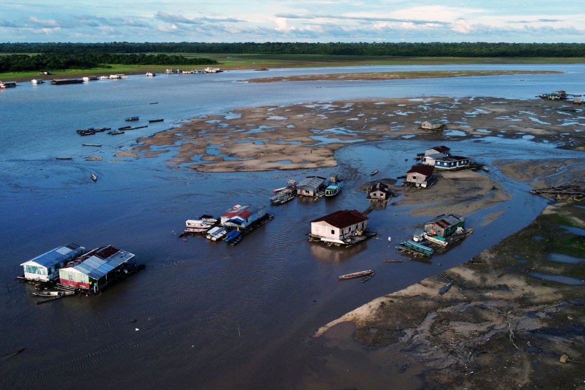 Houseboats sit amid drought-impacted land near the Solimões River, in Tefe, Amazonas state, Brazil
