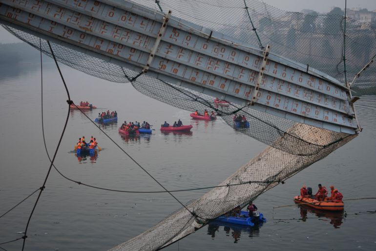 Rescuers on boats search in the Machchu river next to a cable suspension bridge that collapsed in Morbi town of western state Gujarat, India, Monday, Oct. 31, 2022. The century-old cable suspension bridge collapsed into the river Sunday evening, sending hundreds plunging in the water, officials said. (AP Photo/Ajit Solanki)