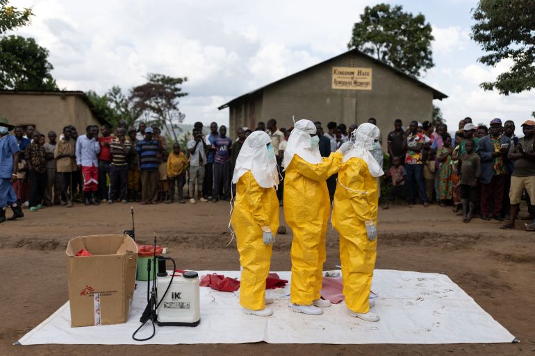 Red Cross workers don PPE prior to burying a 3-year-old boy suspected of dying from Ebola