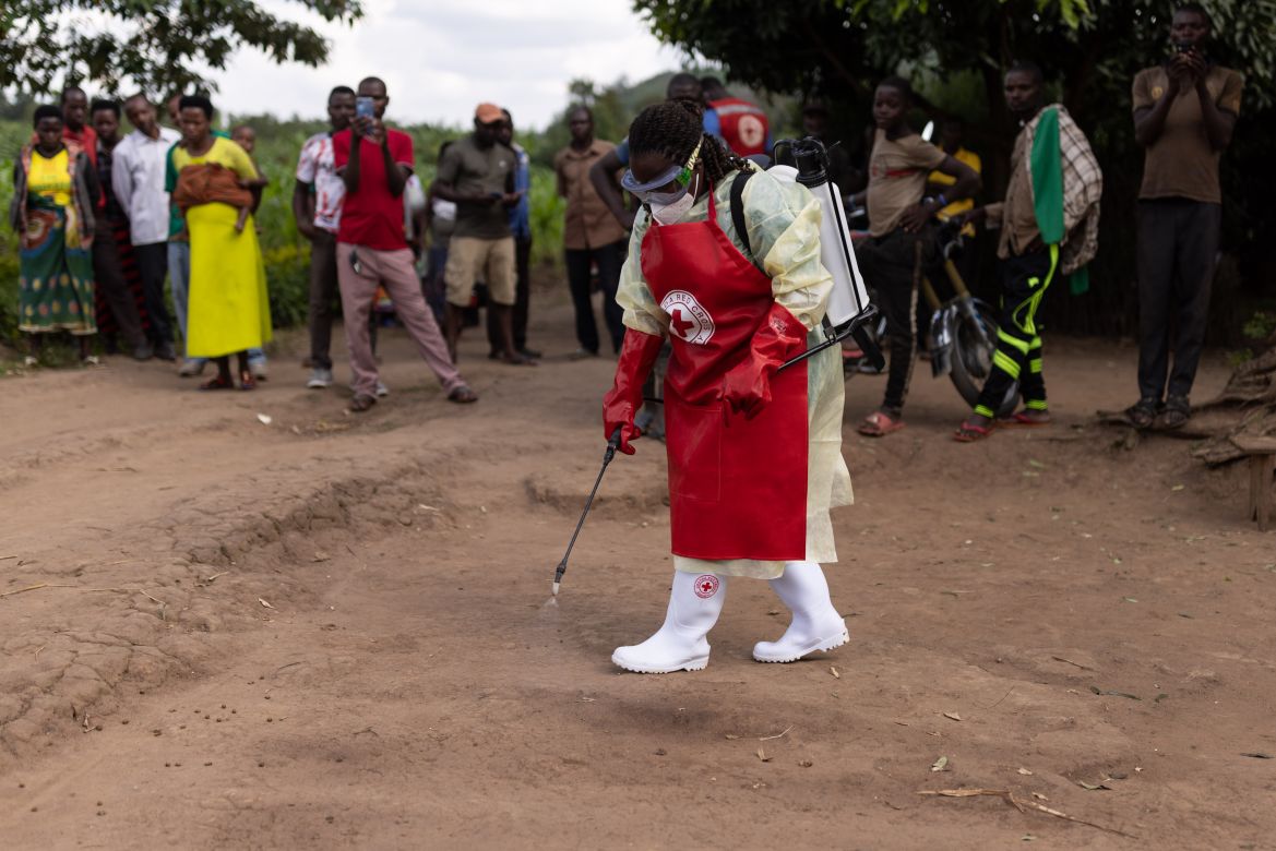 A Red Cross worker creates a 'green zone' before donning PPE prior to burying a 3-year-old boy suspected of dying from Ebola on October 13, 2022 in Mubende, Uganda. Emergency response teams, isolation centres and treatment tents have been set up by the Ugandan health authorities around the central Mubende district after 17 recorded deaths and 48 confirmed cases