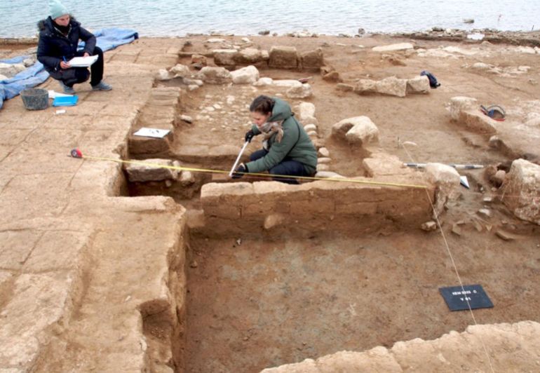 A photo of excavated large buildings from the Mittani period being measured and archaeologically documented.
