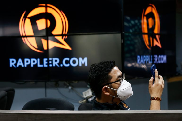 epa10040302 A staff of online news site Rappler views a smartphone at the Rappler office in Pasig City, east of Manila, Philippines 29 June 2022. Rappler CEO Maria Ressa on 29 June announced that the Philippine government's Securities and Exchange Commission (SEC) upheld a January 2018 decision revoking the certificates of incorporation of Rappler. EPA-EFE/ROLEX DELA PENA