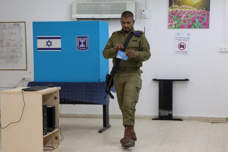 An Israeli soldier casts a ballot a day early in the Israeli general elections