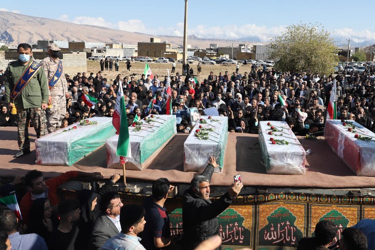 Iranians mourn in front of the coffins of people killed in a shooting attack, during their funeral in the city of Izeh in Iran's Khuzestan province