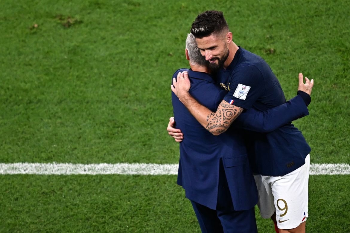 Giroud hugs coach, with a smile on his face