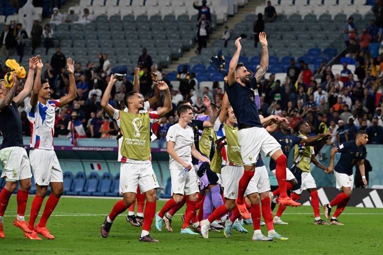 French players celebrate on the pitch after their win.