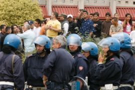 Italian police block locals from entering a Roma camp in a suburb of Naples May 13, 2008. While Romania warned of an outbreak of xenophobia against its people in Italy, locals set fire to two Roma camps in Naples -- previously evacuated by police -- after a 17-year old Roma girl was accused of trying to kidnap an Italian baby. Picture taken May 13, 2008. REUTERS/Ciro De Luca/Agnfoto (ITALY)