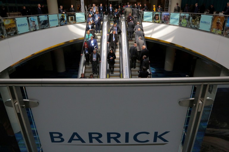 Logo of Barrick Gold with people going down an escalator in the background