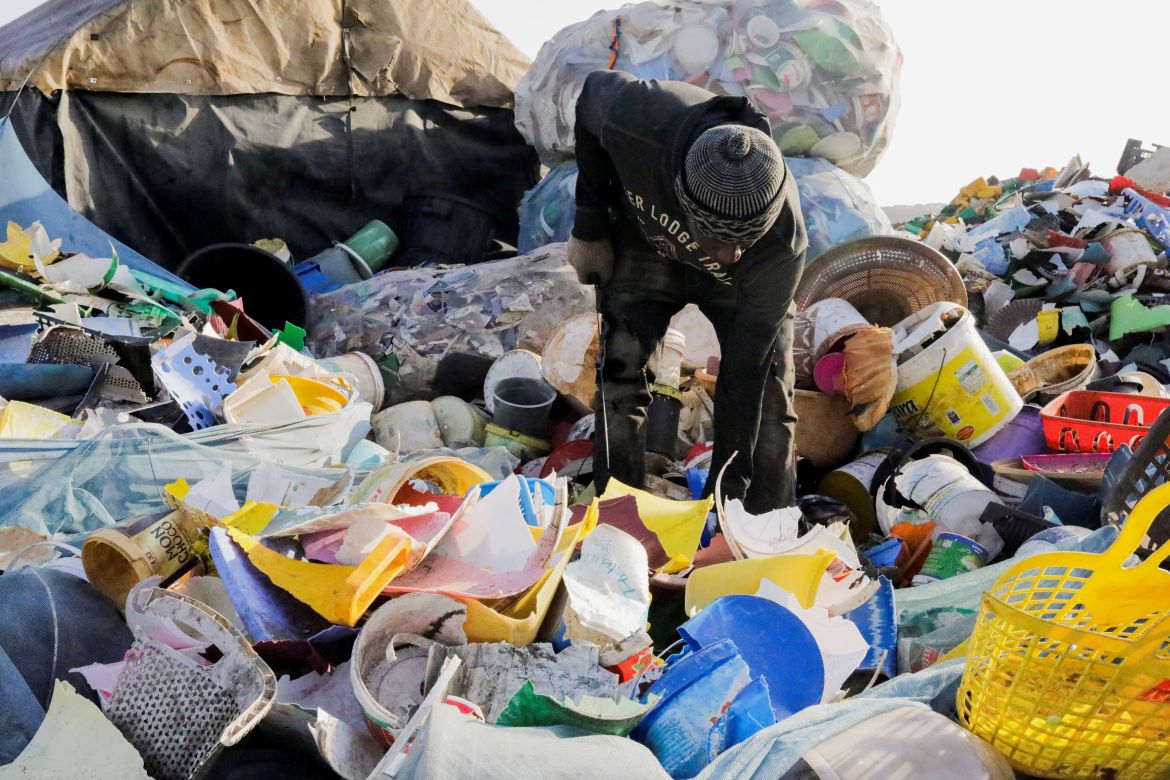 Dame Ndiaye, 31, looks for recyclable plastic material .